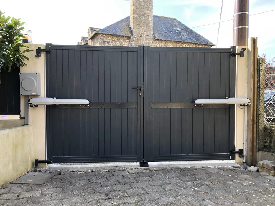Portail extérieur résidentiel en aluminium gris anthracite à deux vantaux, installé entre piliers maçonnés