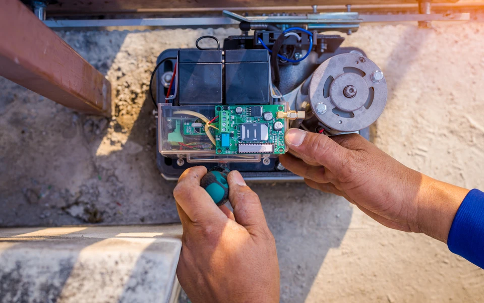 M&eacute;canicien automobile travaillant sous le capot d'un v&eacute;hicule dans un garage professionnel